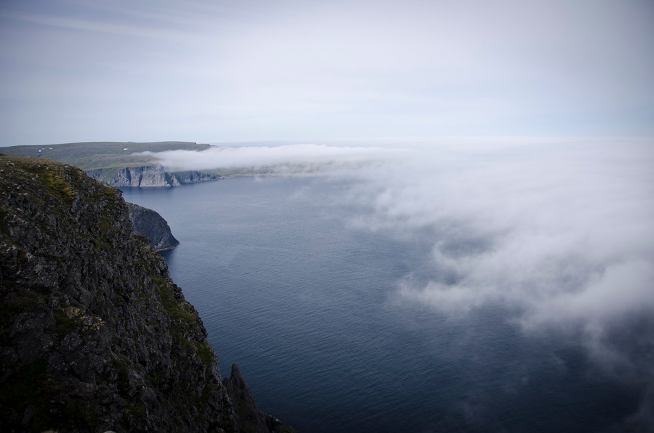Bakom molnen kan man ana spetsen på öns nordligaste udde. Nordkaps klippan är inte nordligast, men den är mest spektakulär!